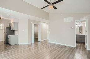 Dallas apartment for rent - A spacious room with a ceiling fan and wooden flooring.