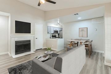 Dallas apartment for rent - A living room with a grey couch and a fireplace.