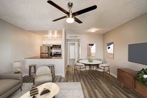 Phoenix apartment for rent - A living room with a couch, chairs, a table, and a ceiling fan.