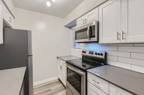 Glendale apartment for rent - A kitchen with a black refrigerator and a black stove top oven.