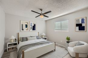 Glendale apartment for rent - A bedroom with a bed, chair, and ceiling fan.