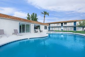 Glendale apartment for rent - A swimming pool in a backyard with a white house and a palm tree.