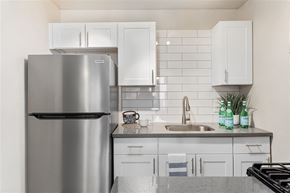 Phoenix apartment for rent - A modern kitchen with a stainless steel refrigerator and white cabinets.