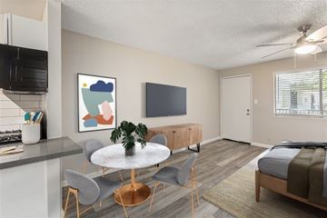 Phoenix apartment for rent - A modern living room with a grey sofa and a round table with chairs.