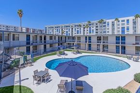 Tempe apartment for rent - A pool area with a blue umbrella and chairs.