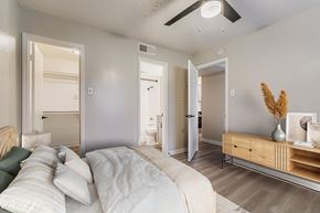 Bedford apartment for rent - A bedroom with a bed, a ceiling fan, and a flat-screen TV mounted on the wall.