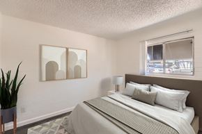 Phoenix apartment for rent - A bedroom with a large bed and a potted plant.