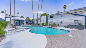 Phoenix apartment for rent - A pool with a white fence and a building in the background.