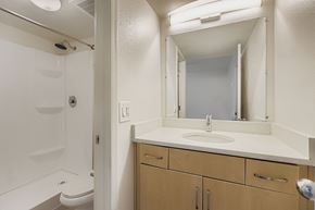 Phoenix apartment for rent - A swimming pool surrounded by a patio with chairs and umbrellas.