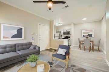 Northlake apartment for rent - A living room with a grey couch, a blue chair, and a coffee table with a plant on it.