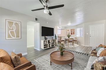 Phoenix apartment for rent - A living room with a brown leather couch and a wooden coffee table.