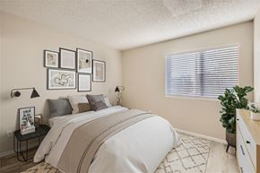 Phoenix apartment for rent - A bedroom with a large bed and a window with blinds.