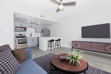 Phoenix apartment for rent - A modern living room with a grey sofa and a wooden coffee table.