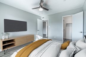 Phoenix apartment for rent - A modern bedroom with a large bed and a flat screen TV on the wall.