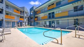 Phoenix apartment for rent - A swimming pool in front of a multi-story apartment building.