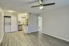 Glendale apartment for rent - A kitchen with white cabinets and a white fridge is visible from a living room.