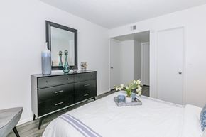 Glendale apartment for rent - A bedroom with a black dresser and a mirror above it.