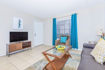 Phoenix apartment for rent - A living room with a grey couch, a wooden coffee table, and a television on a cabinet.