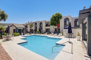 Phoenix apartment for rent - A swimming pool surrounded by lounge chairs and umbrellas.