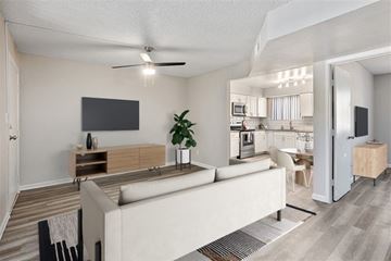 Phoenix apartment for rent - A modern living room with a white couch and a television on the wall.