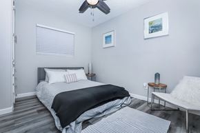 Mesa apartment for rent - A bedroom with a bed, a chair, and a ceiling fan.