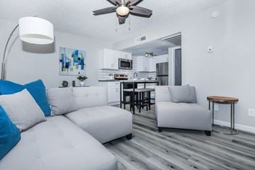Mesa apartment for rent - A modern living room with a white couch and a kitchen in the background.