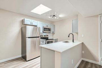 Tempe apartment for rent - A kitchen with a refrigerator, microwave, oven, sink and cabinets.