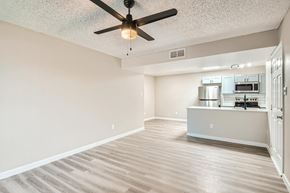 Tempe apartment for rent - A room with a ceiling fan and a kitchenette in the background.