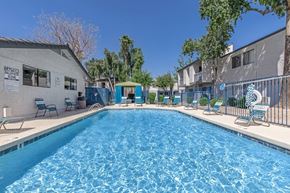 Tempe apartment for rent - A swimming pool surrounded by chairs and a fence.