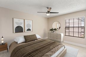 Phoenix apartment for rent - A bedroom with a bed, nightstand, and two wall art pieces.