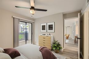 Tempe apartment for rent - A bedroom with a bed, pillows, a ceiling fan, and a dresser with a mirror above it.