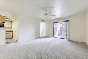 Tempe apartment for rent - A spacious room with a ceiling fan and sliding glass doors leading to a balcony.