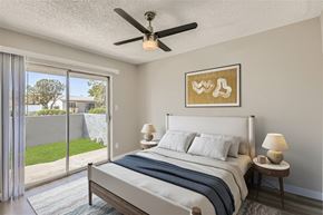Glendale apartment for rent - A bedroom with a large bed, a ceiling fan, and a painting on the wall.