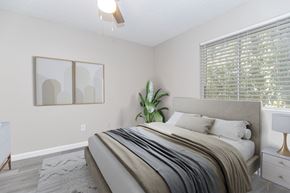 Phoenix apartment for rent - A bedroom with a large bed and a plant on the side table.