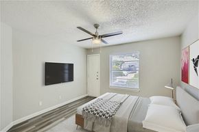 Mesquite apartment for rent - A bedroom with a large bed and a flat screen TV mounted on the wall.
