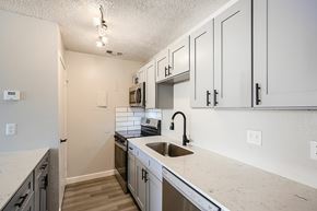 Mesquite apartment for rent - A kitchen with white cabinets and a marble countertop.