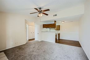 Mesquite apartment for rent - A spacious room with a ceiling fan and a bar area.