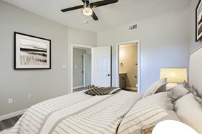 Mesquite apartment for rent - A bedroom with a large bed and a ceiling fan.
