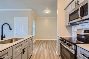 Mesquite apartment for rent - A kitchen with a stove top oven and microwave above it.