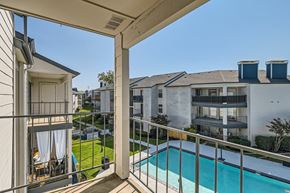 Fort Worth apartment for rent - A balcony with a pool and a view of apartment buildings.