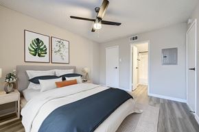 Fort Worth apartment for rent - A bedroom with a large bed and a ceiling fan.