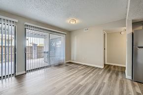 Fort Worth apartment for rent - A spacious room with a sliding glass door and a wooden floor.