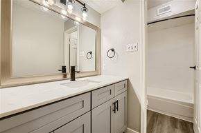 Haltom City apartment for rent - A spacious room with a ceiling fan and carpeted floor.