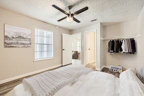 Arlington apartment for rent - A bedroom with a large bed and a ceiling fan.