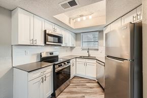 Charlotte apartment for rent - A kitchen with white cabinets and stainless steel appliances.