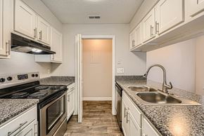 Matthews apartment for rent - A kitchen area with a bar counter and a door leading to another room.