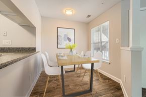 Matthews apartment for rent - A dining room with a table set for two and a painting on the wall.