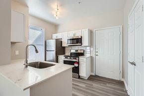Dallas apartment for rent - A kitchen with white cabinets and a sink.