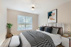 Dallas apartment for rent - A bedroom with a large bed and a window with blinds.
