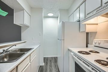 Dallas apartment for rent - A kitchen with a white stove and a white refrigerator.